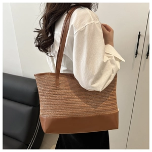 Detail of a chic woven tote bag with brown leather straps shown on a model in a home setting