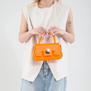 Bright orange crossbody handbag with gold buckle and stylish geometric cutting on flap