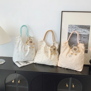 Trois sacs cabas en toile avec motifs floraux et breloques en peluche pour le shopping