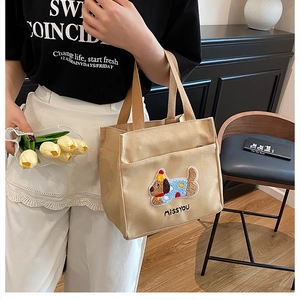 Détail d'un sac à main en toile avec broderie de teckel et texte MISSYOU, style décontracté