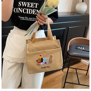Détail de la broderie teckel mignon et texte MISSYOU sur sac en toile beige