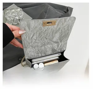 Sac bandoulière argenté montrant l'espace intérieur pour téléphones et maquillage