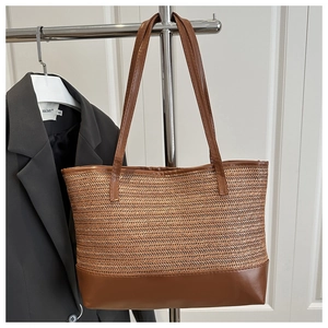 Close-up of fine woven texture and smooth brown faux leather trim on a summer beach tote bag