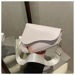 Detail of white crocodile pattern saddle bag with wide strap and gold hardware