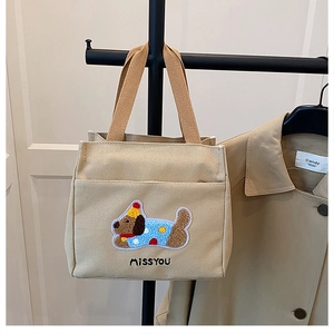 Détail du sac en toile avec broderie chiot en peluche et inscription MISSYOU