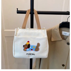 Détail du sac à lunch en toile avec broderie de teckel et poche avant pratique