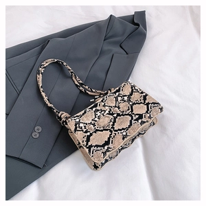 Macro shot of stylish beige faux snakeskin texture on a rectangle handbag detail
