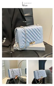 Détail du petit sac carré bleu ciel matelassé avec bandoulière chaîne et fermoir doré