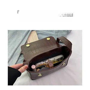 Détail de l'intérieur du sac marron à motif crocodile avec rangement pour rouge à lèvres