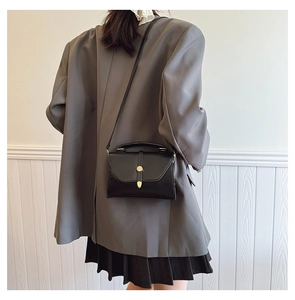 Vue portée montrant la taille et le style du sac à main en cuir noir bandoulière
