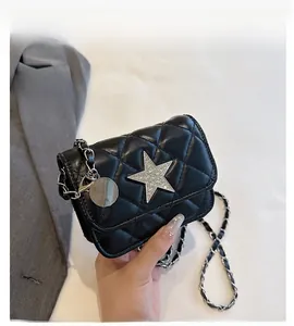 Detail of black quilted shoulder bag featuring silver rhinestone star buckle and chain strap