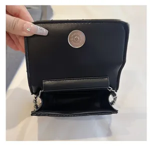Detail view of the black mini bag interior with magnetic clasp and silver chain strap