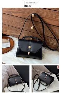 Vue détaillée d'un sac bandoulière en cuir noir mat avec boucle dorée sur fond bois