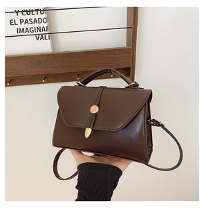 Détail du petit sac carré marron café vintage avec une boucle ronde en métal doré chic