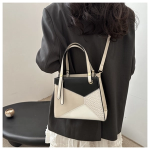 Detail of color-block tote bag showing intricate woven texture and detachable strap