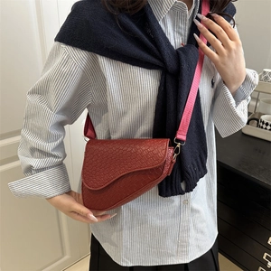 Retro saddle crossbody bag in burgundy woven leather styled with casual striped shirt