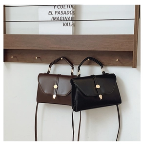 Vue détaillée des sacs bandoulière vintage minimalistes en marron et noir avec boucle dorée