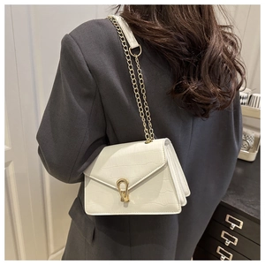 Close-up of white crocodile texture crossbody bag with gold horseshoe buckle and chain strap