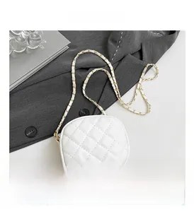 Detail of white quilted camera bag featuring elegant gold chain strap and stitching