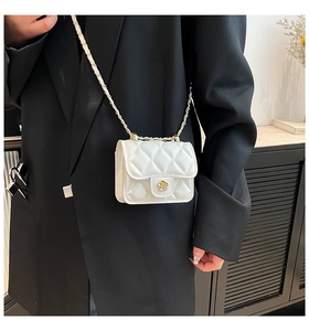 Detail of white quilted mini bag with gold camellia lock and metal chain strap