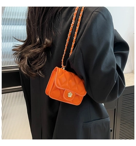 Mini orange quilted crossbody bag with golden flower clasp and leather chain strap