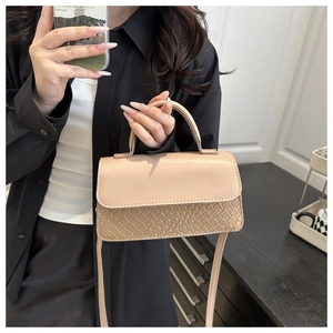 Detail of beige crossbody bag featuring woven texture and smooth leather flap