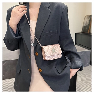 Detail of pink quilted mini crossbody bag featuring a sparkling star-shaped crystal ornament
