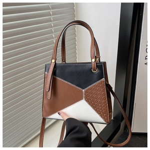 Detail of color-block tote bag featuring woven texture and white contrast stitching