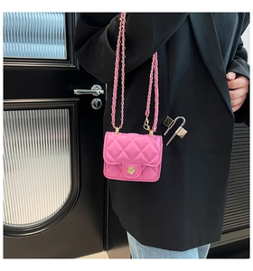 Détail du sac bandoulière rose matelassé avec fermoir fleur dorée et bandoulière chaîne