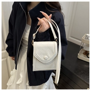 Detailed close-up of a white quilted crossbody phone bag with gold-tone hardware and strap