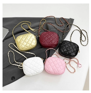 Close-up of quilted camera bags in five colors with metallic chain straps on suit fabric