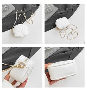 Detail view of mini white quilted crossbody bag with gold chain and zip closure