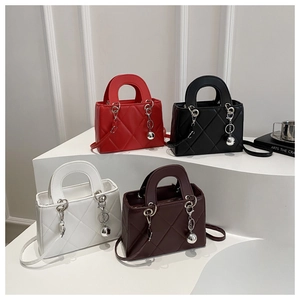 Detailed view of four quilted handbags in red, black, and white on a display stand