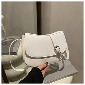 Detail of white PU leather saddle bag with magnetic closure and adjustable strap