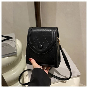 Macro detail of black quilted faux leather crossbody phone bag with gold metal buckle
