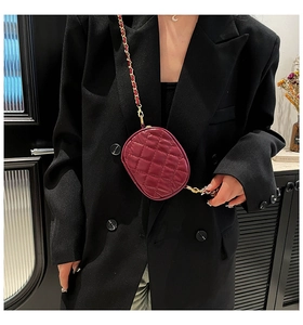 Detailed view of wine red quilted round crossbody bag with elegant gold chain strap