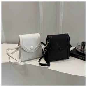 Detail view of black and white quilted square bags with gold metal hardware adjusters