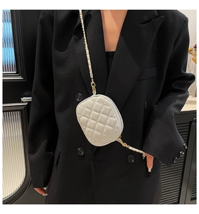 Detailed close-up of a white quilted mini crossbody bag with a gold metal chain strap