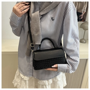 Fashionable black crossbody bag with dual-texture leather and elegant top handle strap