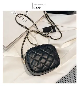 Detailed view of black quilted crossbody bag with gold chain strap on a white background