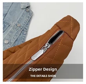 Détail de la fermeture éclair argentée et matelassage sur le sac cabas marron