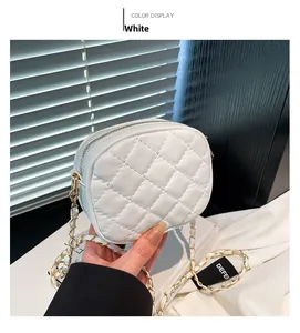 Detail of white quilted crossbody bag with golden chain strap and rhombus stitching