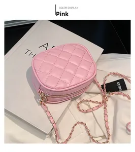 Close-up of pink quilted crossbody bag with gold chain strap and macro leather texture