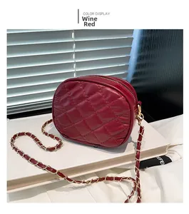 Detail showing wine red quilted texture and golden chain strap of the camera bag