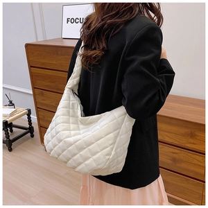 Vue détaillée d'un grand sac cabas matelassé blanc porté à l'épaule pour femme