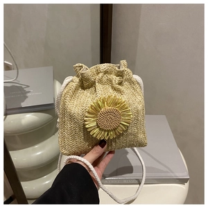 Close-up of woven bucket bag with 3D sunflower decor and white rope drawstring strap