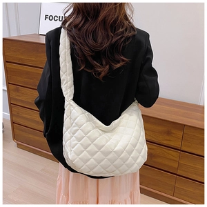 Détail d'un sac cabas blanc matelassé avec motif à losanges et bandoulière large