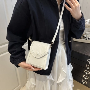 Minimalist white quilted leather crossbody phone bag shown on a female model