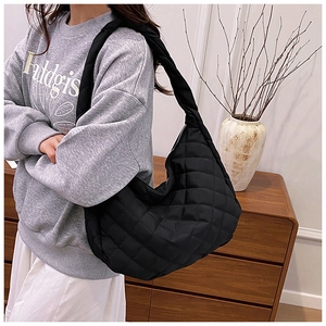 Gros plan du sac fourre-tout matelassé noir avec texture souple et large bandoulière
