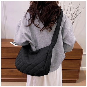 Vue arrière du sac cabas matelassé noir avec large bandoulière porté par un mannequin